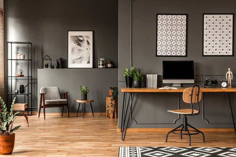 Patterned_posters_above_desk_with_computer_monitor_in_grey_home_office_interior_with_plants