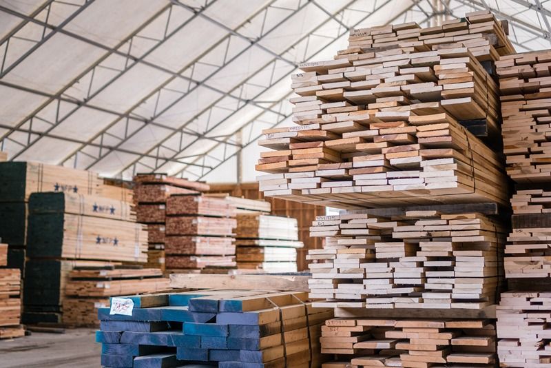 Stacks_of_lumber_being_stored_in_a_warehouse