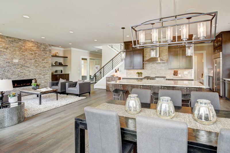 Beautiful_living_room_interior_in_new_luxury_home_with_view_of_kitchen._Home_interior_with_hardwood_floors_and_open_floor_plan_showing_dining_room,_kitchen,_and_living_room._Has_high_vaulted_ceilings.