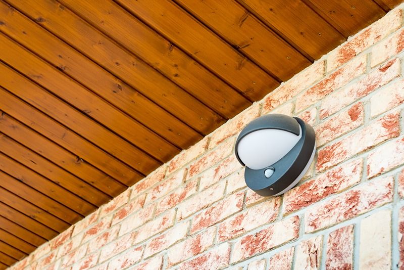 Modern_wall_lamp_with_motion_and_light_sensor_on_the_brick_wall_-_pathway_or_wall_light_for_modern_design_building_or_house_-_motion_activated_porch_light_-_part_of_home_security_system